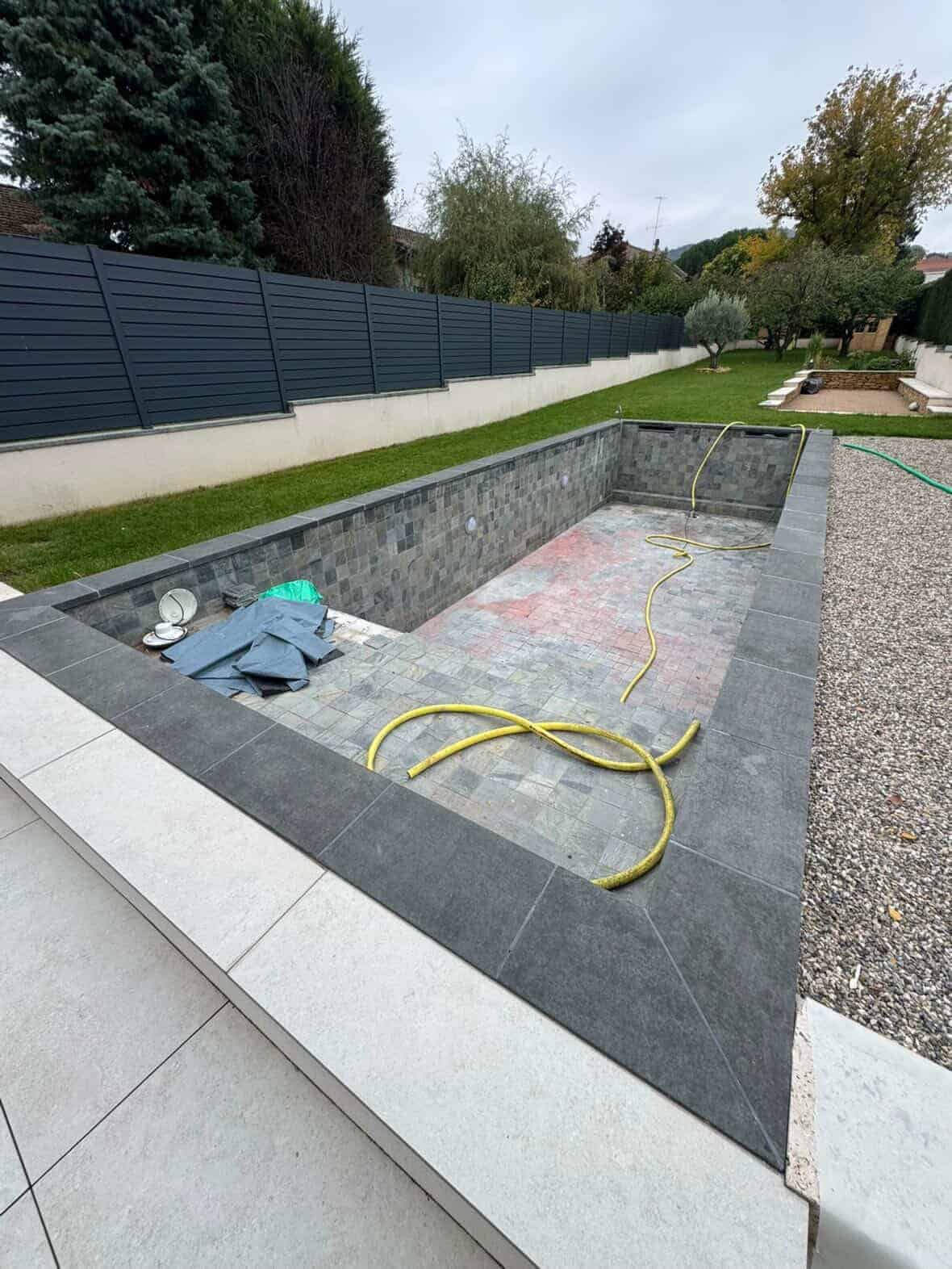 Piscine vidée avant rénovation, ancien revêtement abîmé